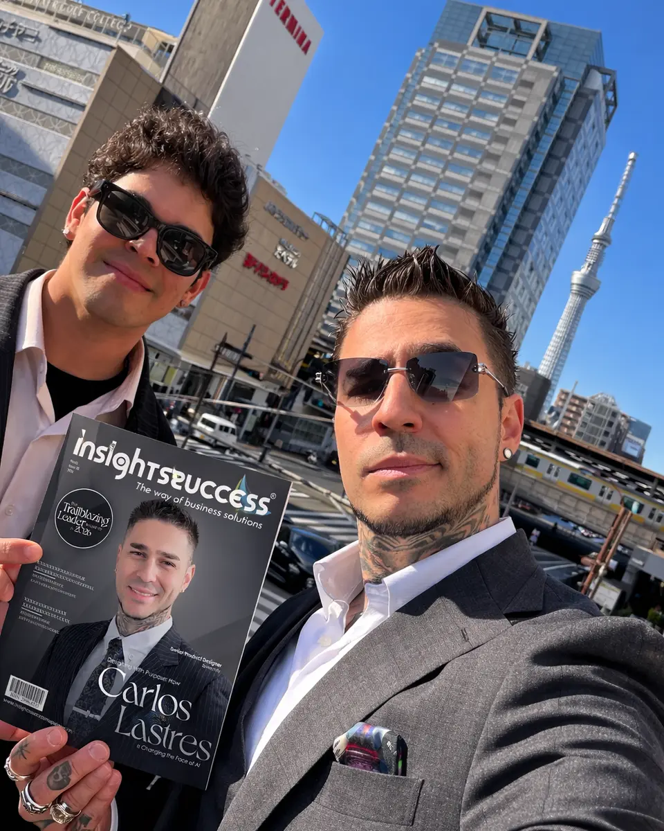 Valerio y Carlos frente al Tokyo Skytree, Carlos sostiene una revista Insights Success con él en la portada